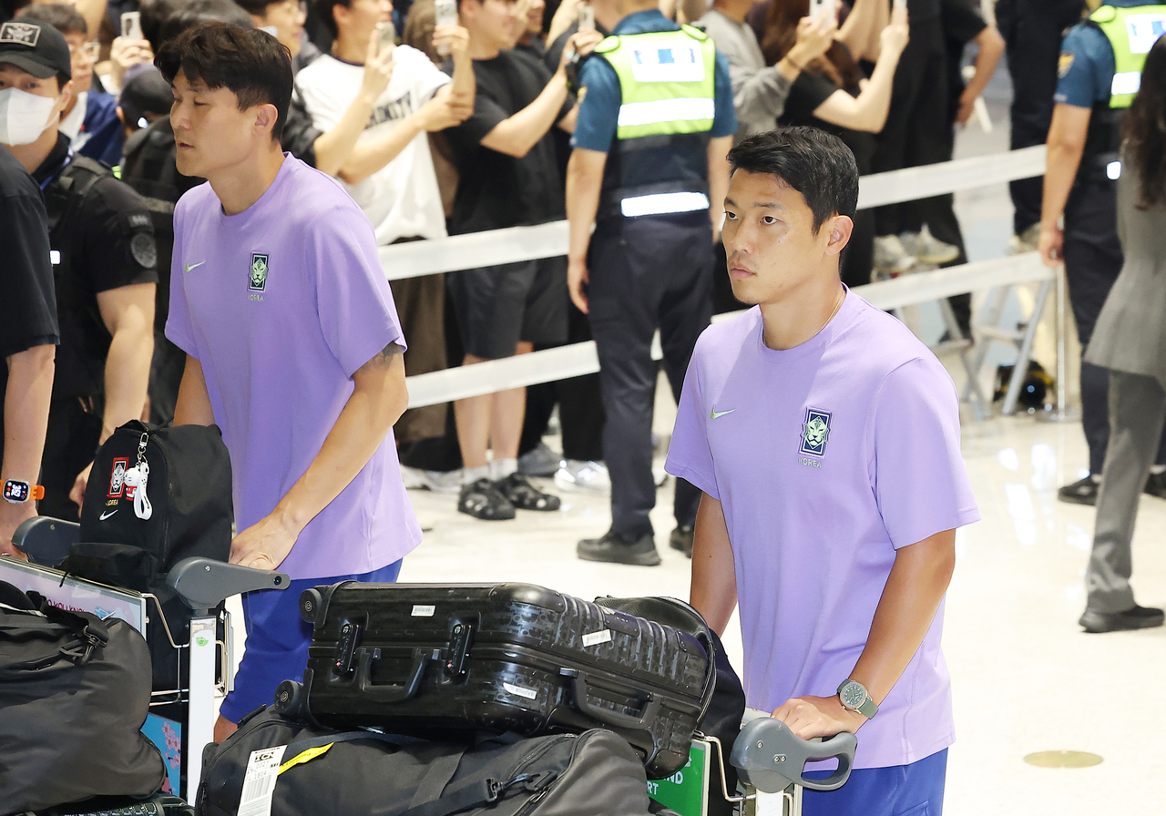 김민재와 황희찬이 지난 6월 30일 인천국제공항 제2여객터미널을 통해 입국하고 있다. [연합]
