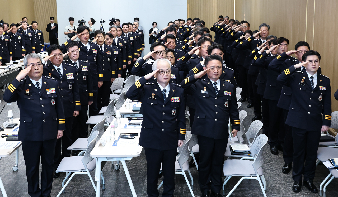 Regional police chiefs salute the flag during a meeting held at the Korean National Police Agency headquarters located in Seodaemun-gu, Seoul on Thursday. (Yonhap)