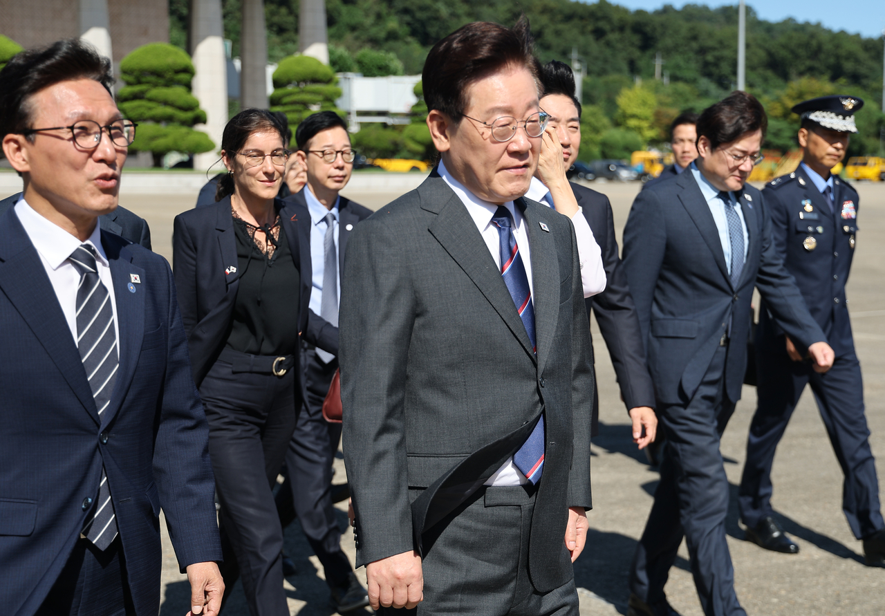 President Lee Jae Myung (center) walks toward Air Force One at Seoul Air Base in Seongnam, Gyeonggi Province, on Sunday before departing for a state visit to France. (Yonhap)