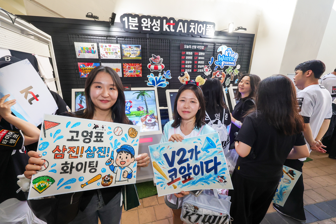 KT 위즈파크에 설치된 인공지능(AI) 치어풀 부스에서 이용자들이 직접 만든 응원문구를 들고 있는 모습.  [KT 제공]