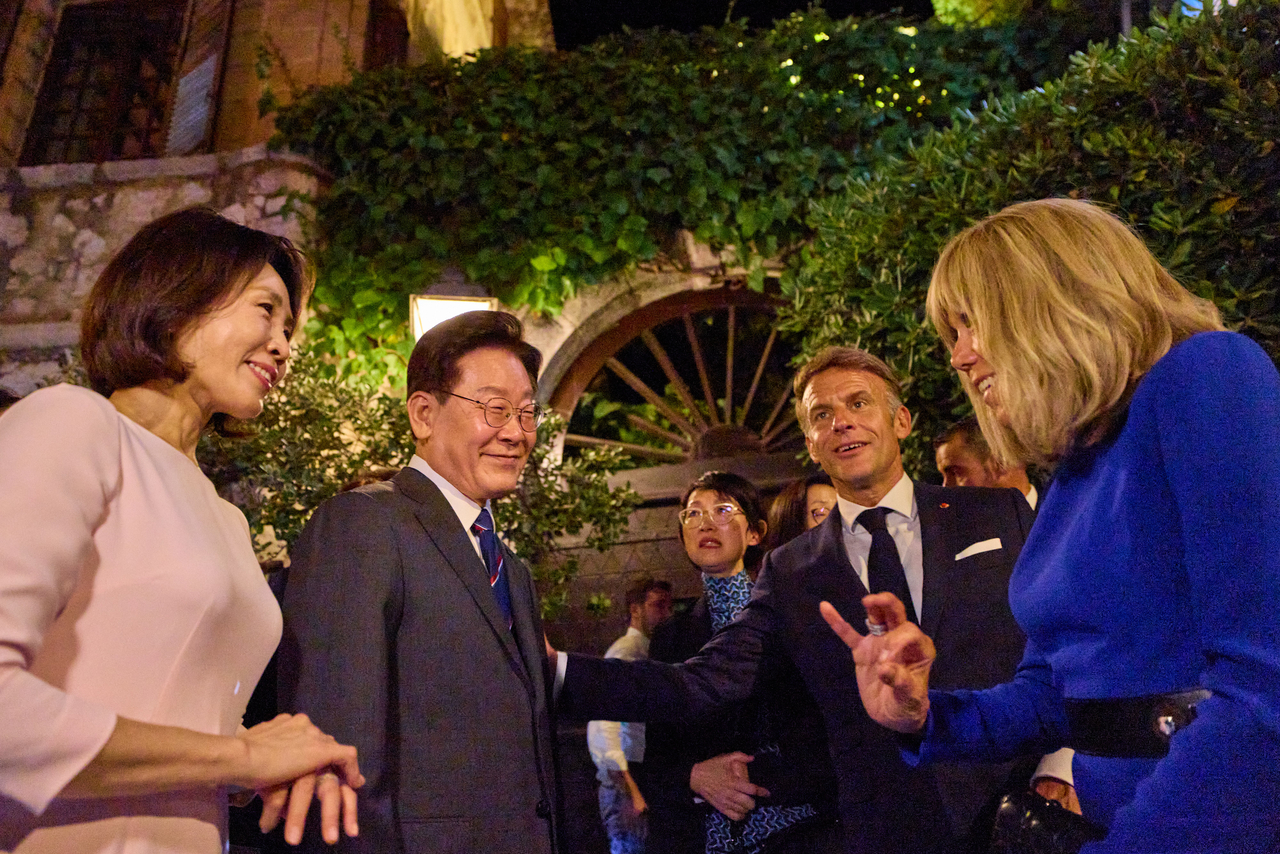 South President Lee Jae Myung (second from left) and his wife, Kim Hea Kyung (left), talk with French President Emmanuel Macron (second from right) and his wife Brigitte Macron in Nice, France, on Sunday, in this photo posted on Lee's social media. (Yonhap)