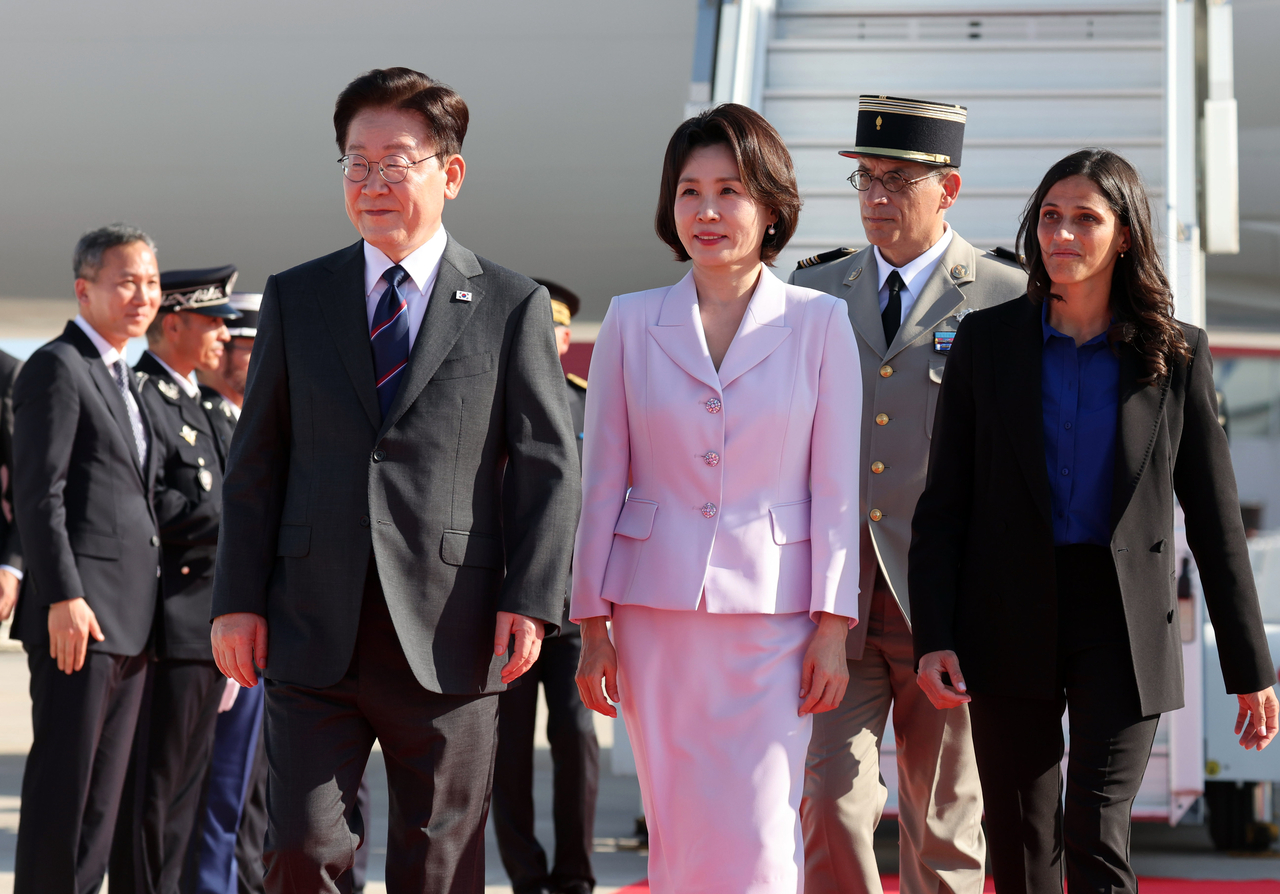 President Lee Jae Myung (L) and his wife, Kim Hea Kyung, arrive at Nice Cote d'Azur Airport in Nice, France, on Sunday. (Yonhap)