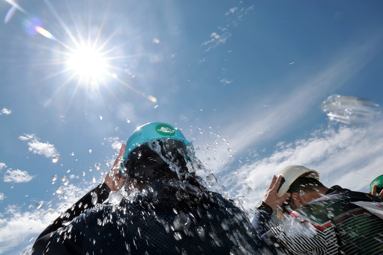 Members of the Korean Confederation of Trade Unions pour ice water over their heads during an Aug. 11 news conference outside the National Assembly in Seoul, calling on the government to allow construction workers to stop work during extreme heat. (Yonhap)