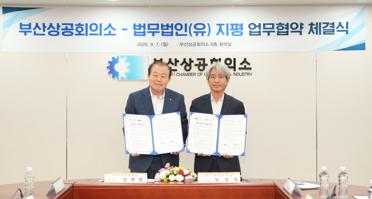 Busan Chamber of Commerce Chairman Yang Jae-saeng (left) and Jipyong LLC Managing Partner Lim Sung-taek sign an MOU at the chamber's office Monday. [Busan Chamber of Commerce]