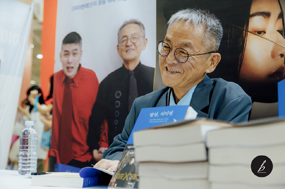 Author Jeon Gyeong-cheol attends a signing event for his book "Goodbye, Peter Pan," about his life raising a son with severe autism. (Kakao)