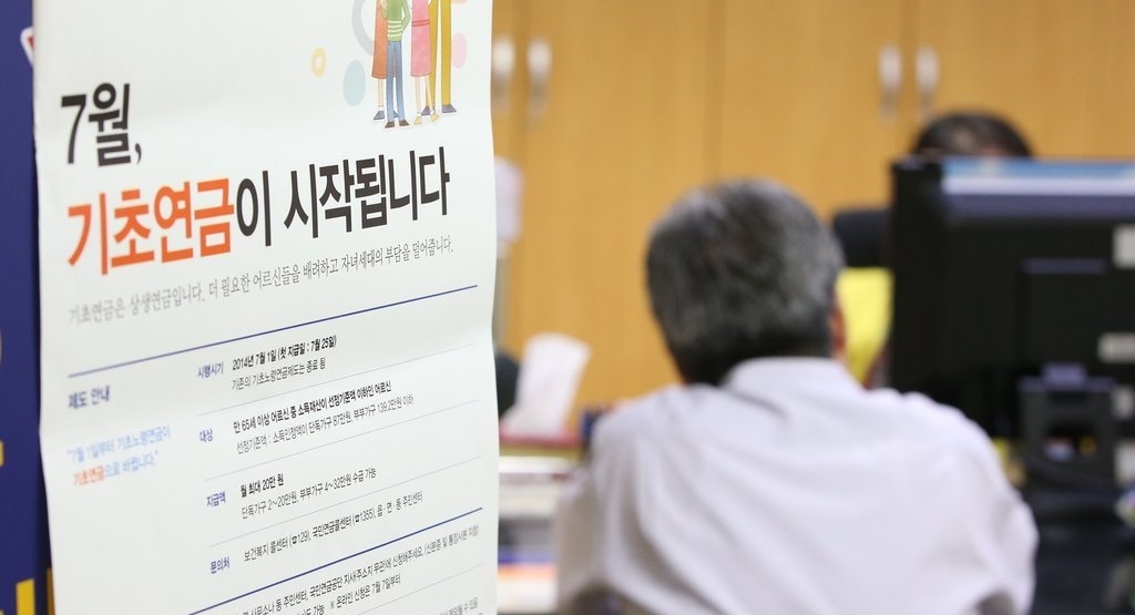2014년 7월 25일 기초연금 첫 지급일을 하루 앞둔 24일 오후 서울 국민연금 종로중구지사 기초연금 접수 창구를 찾은 한 수급 대상자가 담당자와 상담하고 있다. [연합]