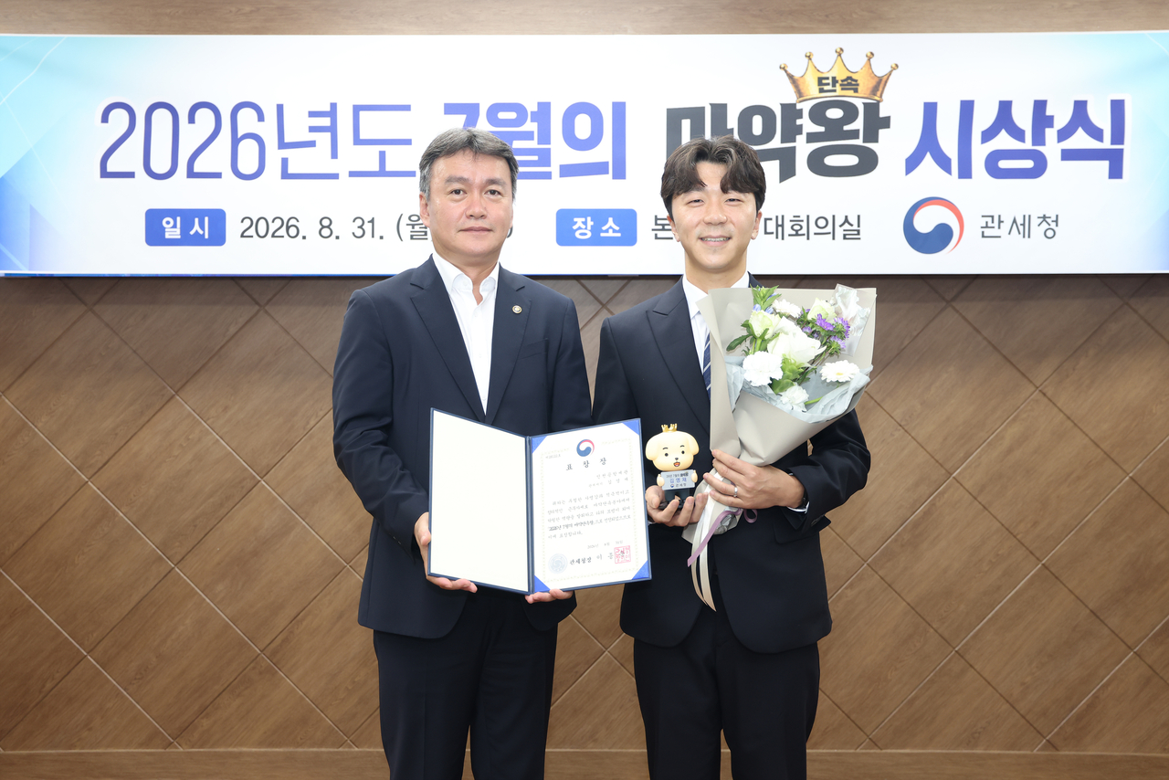이종욱 관세청장(왼쪽)이 7일 초대 마약단속왕으로 인천공항세관 김영재 주무관을 선정해 시상한 뒤 기념 촬영하고 있다.