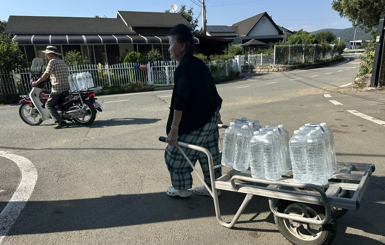 Residents receive bottled water at a senior center in Cheongdo-gun, North Gyeongsang Province, on Aug. 2, after water service was cut off in parts of the county amid a surge in water demand. (Yonhap)