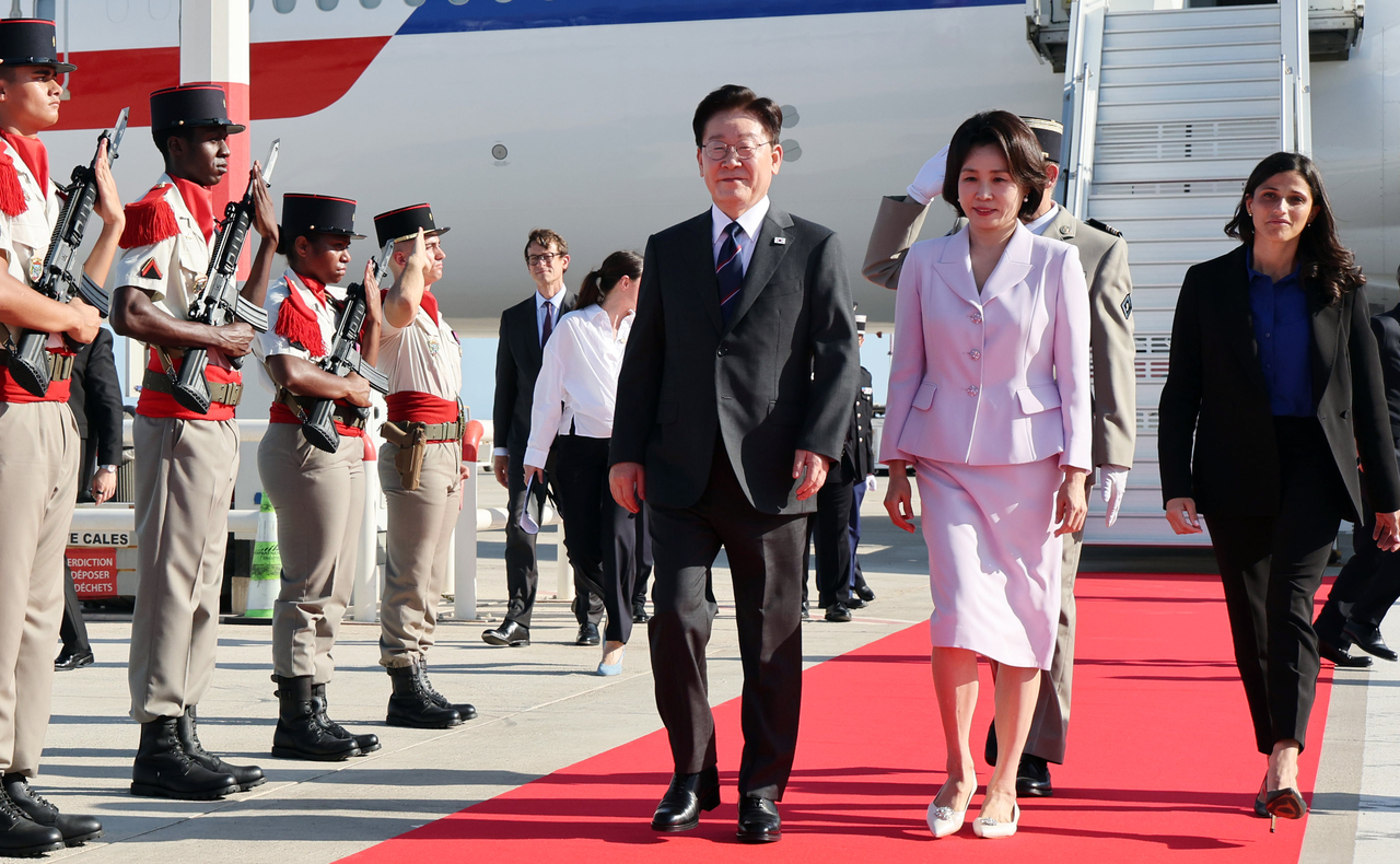 President Lee Jae Myung and First Lady Kim Hye Kyung head to their official vehicle after arriving aboard Air Force One at Cote d'Azur Airport in Nice, France, on Sunday (local time). (Yonhap)