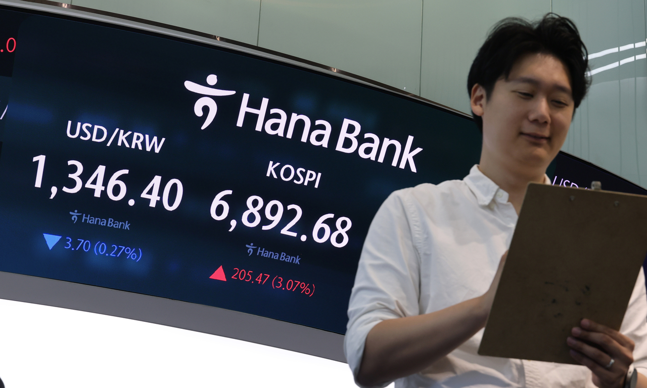 Employees monitor stock and exchange rate movements at Hana Bank's dealing room in Jung-gu, Seoul, on Monday. [Yonhap]