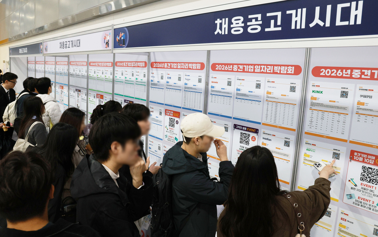 Job seekers browse recruitment postings from participating companies at the 2026 Mid-Tier Firm Job Fair. [Yonhap]