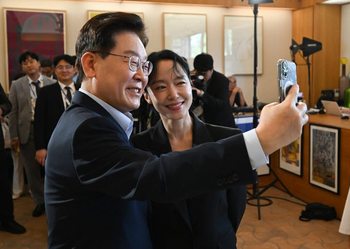 President Lee Jae Myung (left) poses for a photo with actor Jeon Do-yeon after meeting with South Korean filmmakers and actors at the Lumiere Summit at the Fondation Maeght in Saint-Paul-de-Vence, southern France, Monday. (Yonhap)