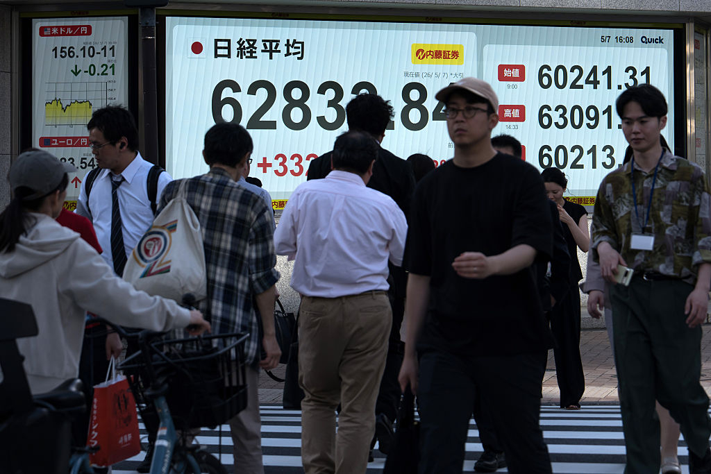 Japan appears set to mark its longest postwar economic expansion, extending its growth streak to 74 consecutive months. The photo shows pedestrians outside a securities firm in Tokyo in May. (Getty Images)