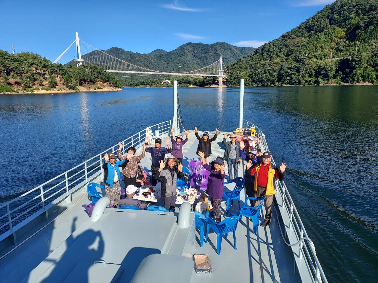 Residents cheer after the Sangmuryong suspension bridge opens, finally connecting the village to the outside world.