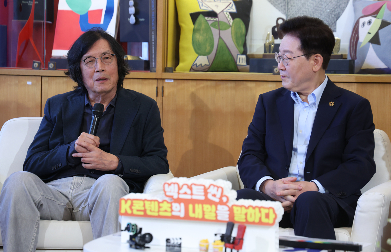 Director Lee Chang-dong (left) and President Lee Jae Myung attend a meeting with Korean filmmakers and actors on the sidelines of the Lumiere Summit at the Fondation Maeght in Saint-Paul-de-Vence, France, Monday. (Yonhap)