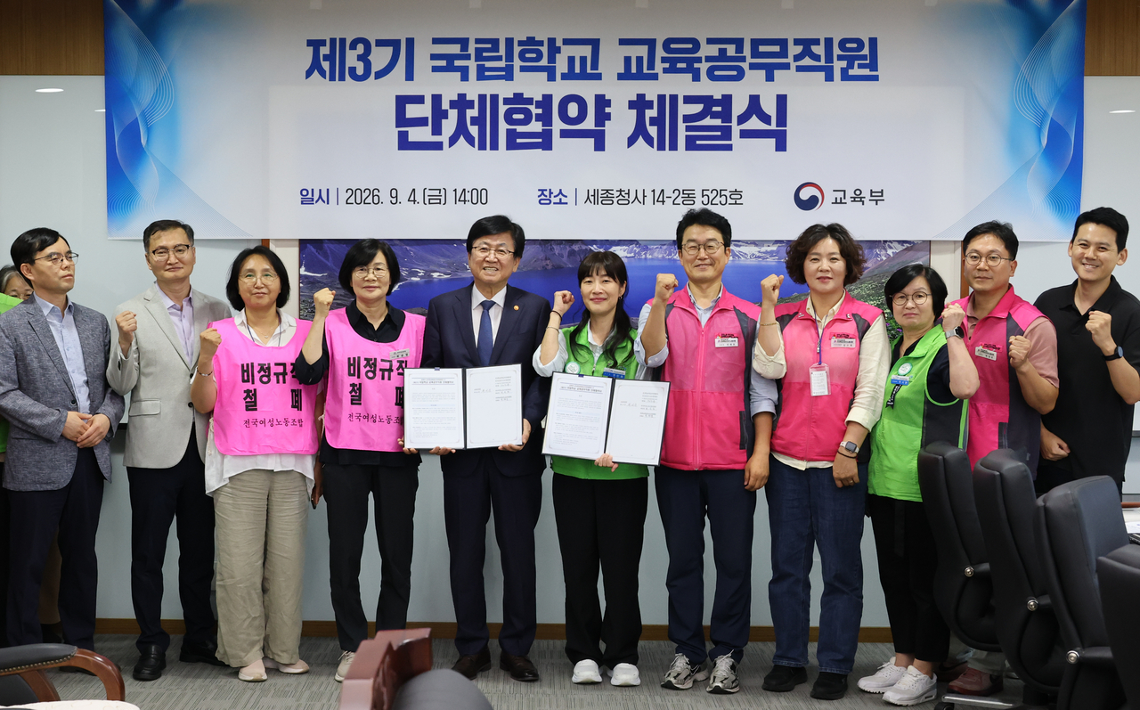최교진 교육부 장관(왼쪽 다섯번째)이 4일 세종시 정부세종청사에서 전국학교비정규직연대회의 대표자들과 ‘국립학교 교육공무직원 단체협약’을 체결한 뒤 기념촬영 하고 있다. 이번 단체협약은 교육부 장관이 관할하는 전국 42개 국립학교 소속 교육공무직원에게 적용된다. 주요 합의사항은 유급병가 일수 확대, 방학 중 비근무자 연차 휴가일수 확대, 산업재해 휴직자 급여 차액 보전 기간 확대 등이다. [연합]
