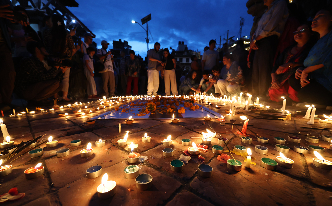 People light candles as they observe a national day of mourning for victims of flash floods in Kathmandu on Monday. (AFP-Yonhap)