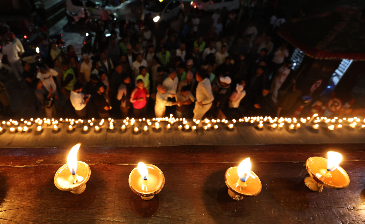 People light candles as they observe a national day of mourning for victims of flash floods in Kathmandu on Monday, as families of missing hydropower workers feared trapped in tunnels prayed rescuers might yet find them alive. (AFP-Yonhap)