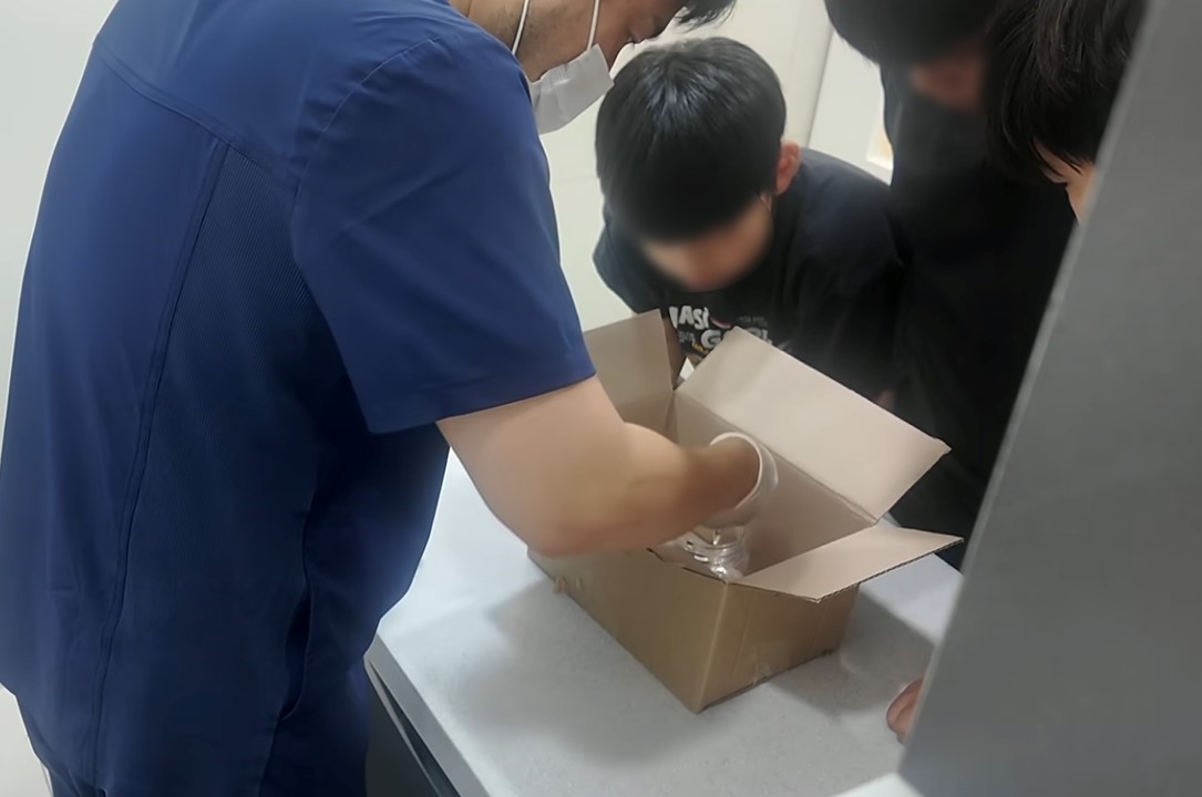 A screen capture from the video shows three children and the vet trying to save a sick mouse at an animal clinic on July 19. (YouTube @donghang365)