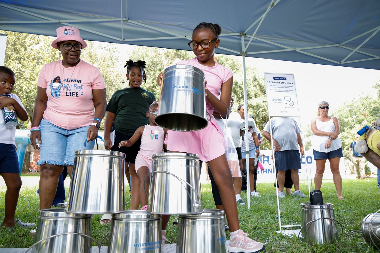A Donaldsonville teenager takes part in the "stack steel buckets within 29 seconds" game, symbolizing 2029, HPLS's target completion year, during the "HPLS Community Day" event. (Hyundai Steel)