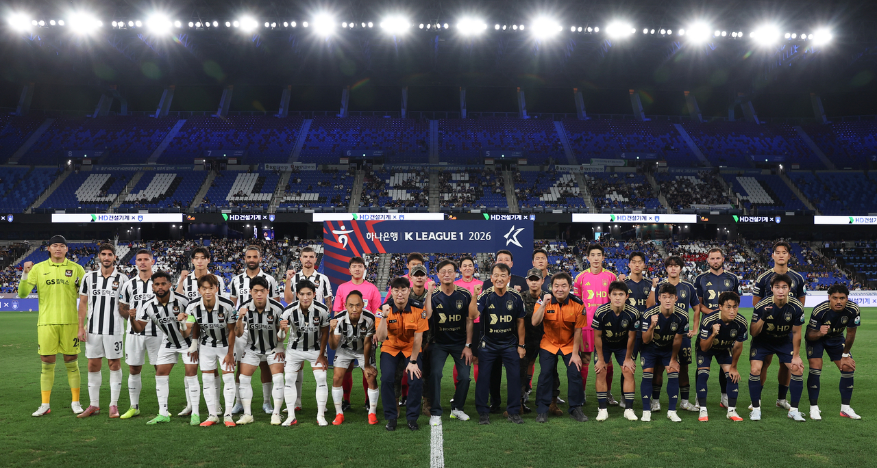HD Construction Equipment holds its "Brand Day" event at Munsu World Cup Stadium in Ulsan on Tuesday, with President Moon Jae-young posing for a commemorative photo alongside firefighters, service members and the team's players.