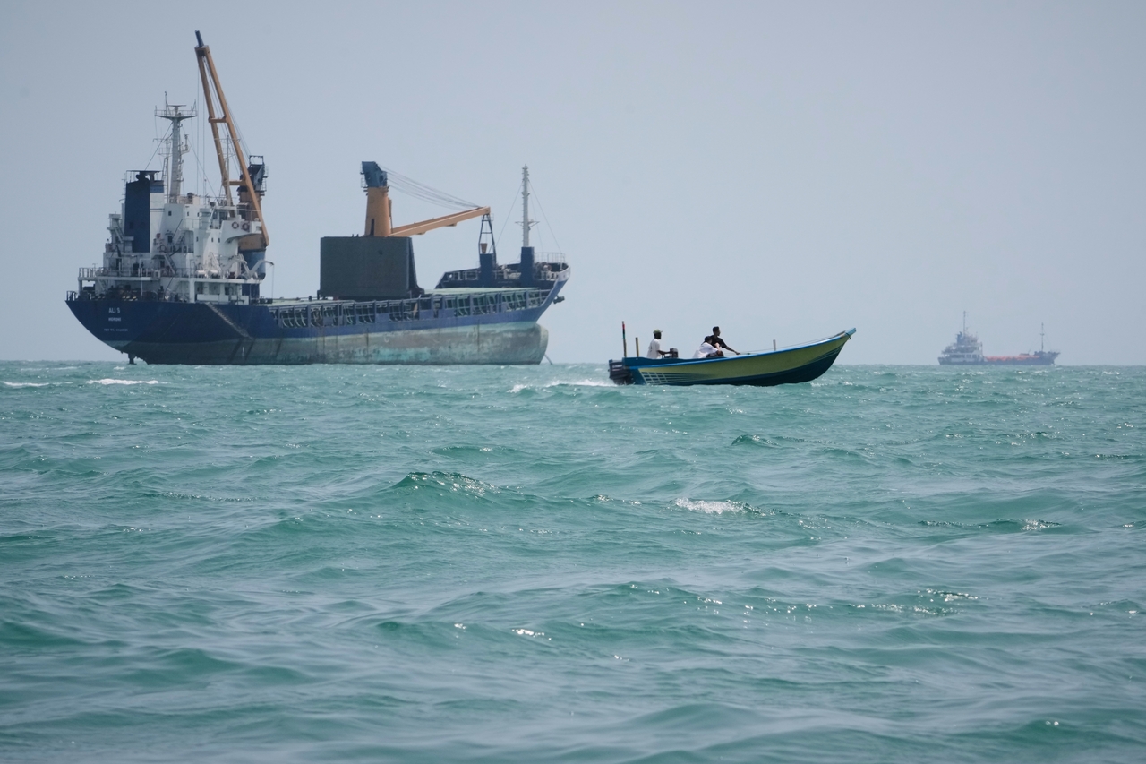 A motorboat passes a general cargo ship anchored in the Strait of Hormuz off Bandar Abbas, Iran on Sunday. (AP-Yonhap)