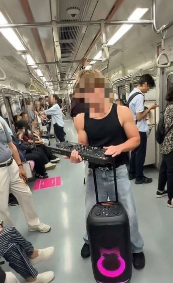 TikToker Streichbruder dances to music blasting from a large speaker inside a subway train in Seoul. (TikTok @simon.bth)