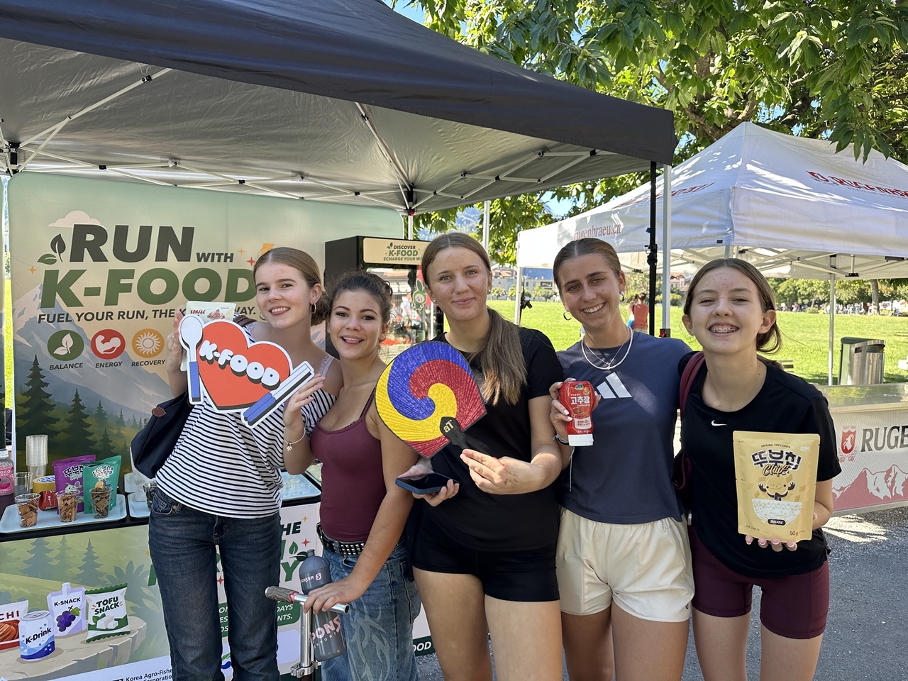 Visitors gather at the K-food promotional booth, sampling Korean snacks and drinks under the theme “Run with K-Food.” (aT)