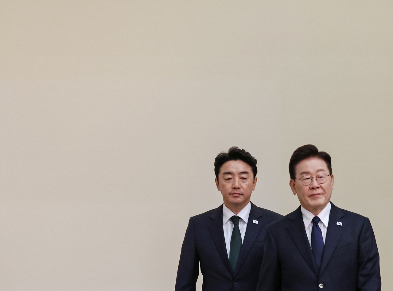 President Lee Jae Myung (left) and Chief of Staff Kang Hoon-sik enter a weekly meeting with senior presidential aides and secretaries at Cheong Wa Dae in Seoul on Sept. 3. (Yonhap)