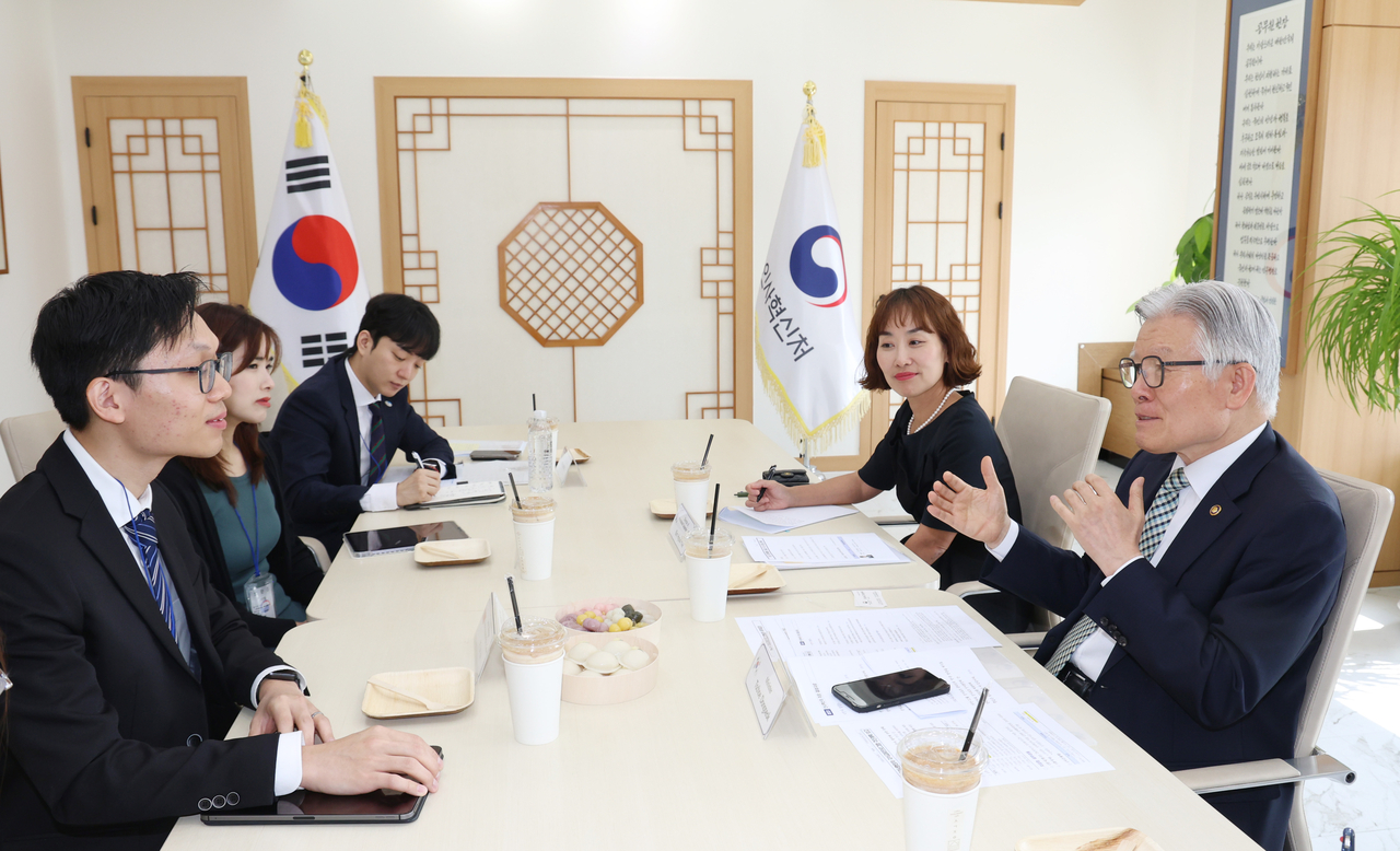 Minister of Personnel Management Tschoe Dong-seok (right) speaks with Singaporean officials at the Government Complex Sejong on Wednesday. (Ministry of Personnel Management)