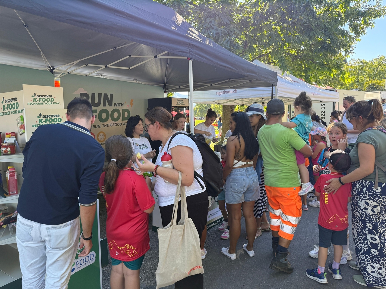 Crowds engage with the Run with K-Food pavilion, enjoying tastings and interactive programs against the scenic backdrop of the Swiss Alps. (aT)