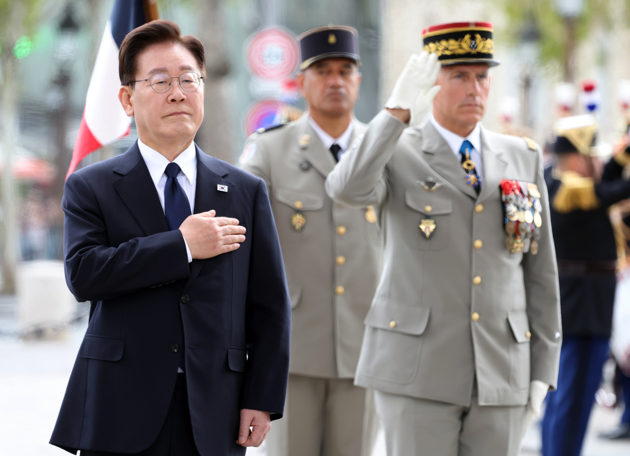 President Lee Jae Myung salutes the national flag as the South Korean national anthem is played after laying a wreath at the Tomb of the Unknown Soldier beneath the Arc de Triomphe in Paris on Tuesday, during his state visit to France. (Yonhap)