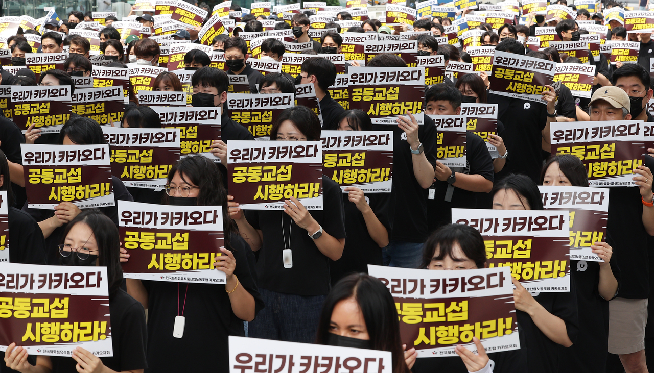 지난달 26일 경기도 성남시 분당구 판교역 광장에서 열린 ‘카카오뱅크 파업투쟁 결의대회 및 카카오 분할 반대 공동교섭 선포식’에서 전국화학섬유식품산업노동조합 카카오지회 노조원들이 피켓을 들고 있다. [연합]