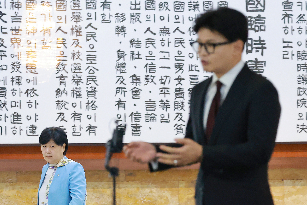 국회 법제사법위원장인 서영교 더불어민주당 의원이 9일 국회 로텐더홀에서 김승원 법무부 장관 후보자와 관련해 취재진 질문에 답하는 한동훈 무소속 의원을 보며 지나가고 있다. [연합]
