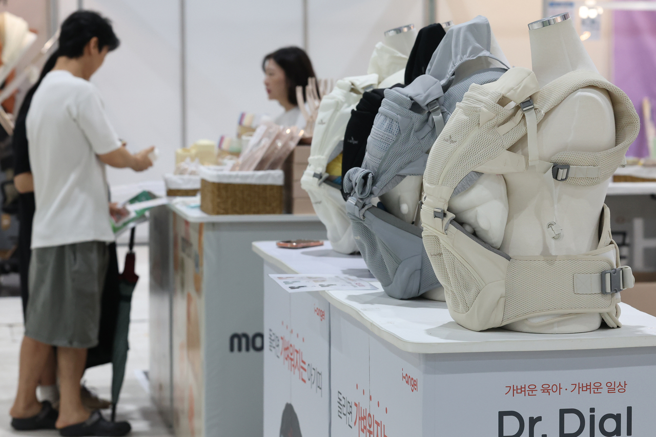 A couple looks at child-related products in a baby fair in Gangnam-gu, Seoul, Aug. 20. (Yonhap)