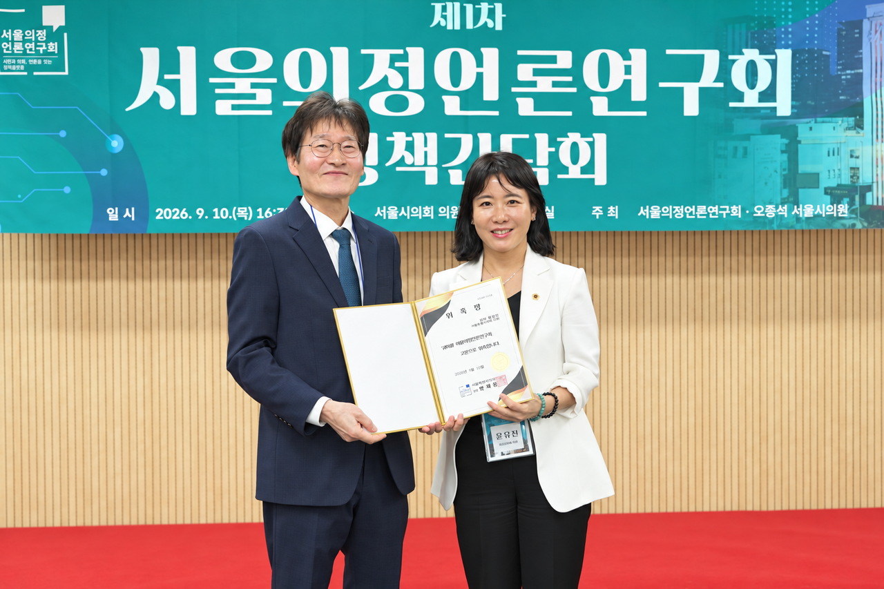 Seoul City Council member Yoon Yu-jin (right) poses for a photo after receiving her appointment certificate as auditor at the launch ceremony and first policy meeting of the Seoul Council-Press Research Society, held Thursday at Meeting Room No. 1 in the Seoul Metropolitan Council members' office building.