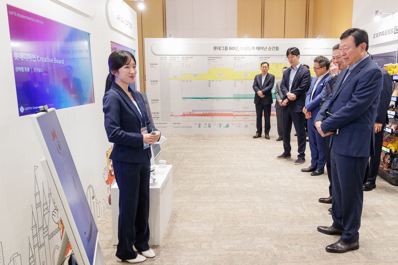 신동빈 롯데 회장이 10일 젊은 디자이너들의 AI 프로젝트 결과물인 ‘로티로리 로봇 롯데월드 안내 서비스’에 대한 설명을 듣고 있다. [롯데지주 제공]