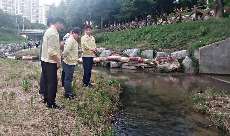 조용익 부천시장<오른쪽>이 지난 6일 물고기 폐사 및 거품 유입 상황을 보고 받은 직후 현장을 찾아, 조치 사항을 확인하고 철저한 원인조사와 시민 안전 최우선을 당부했다. [부천시 제공]