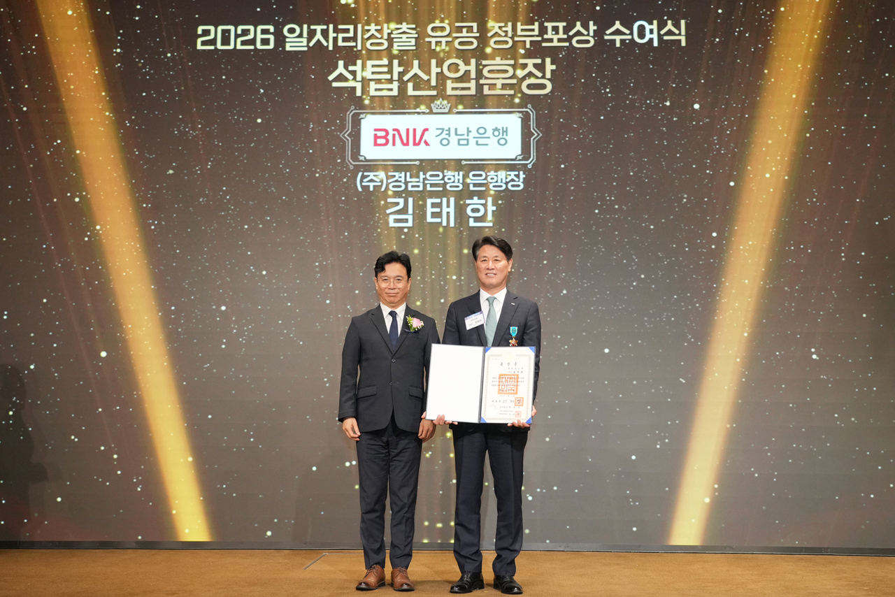 김태한(오른쪽) BNK경남은행장이 김영훈 고용노동부 장관으로부터 석탑산업훈장을 받고 있다. [경남은행 제공]