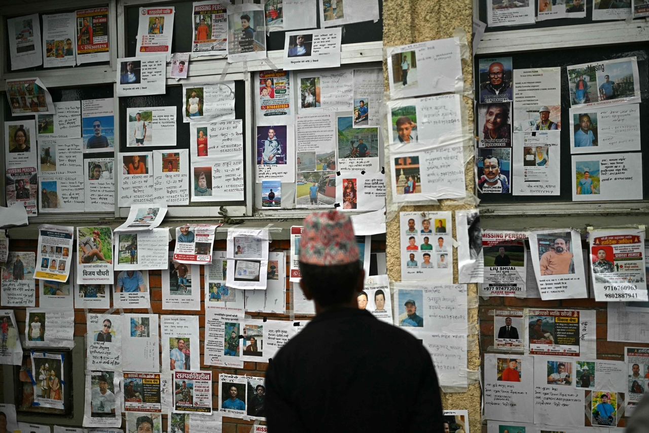 A man looks at photographs of missing persons outside a morgue in the aftermath of flash floods in Kathmandu on Wednesday. (AFP-Yonhap)