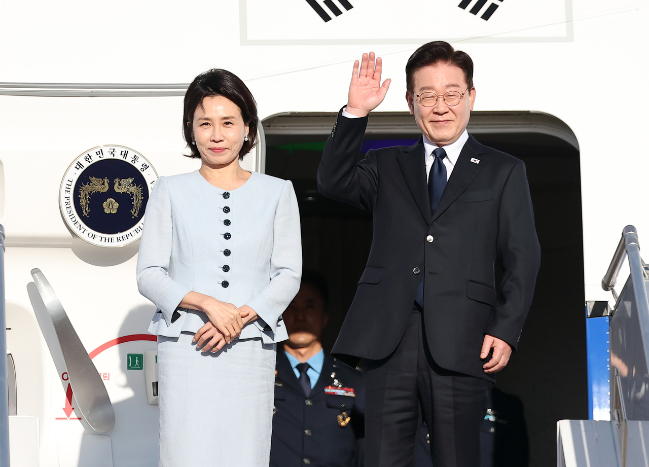President Lee Jae Myung and first lady Kim Hye Kyung wave goodbye to well-wishers aboard Air Force One at Orly Airport in Paris on Sept. 9, 2026, after concluding their state visit to France. (Yonhap)