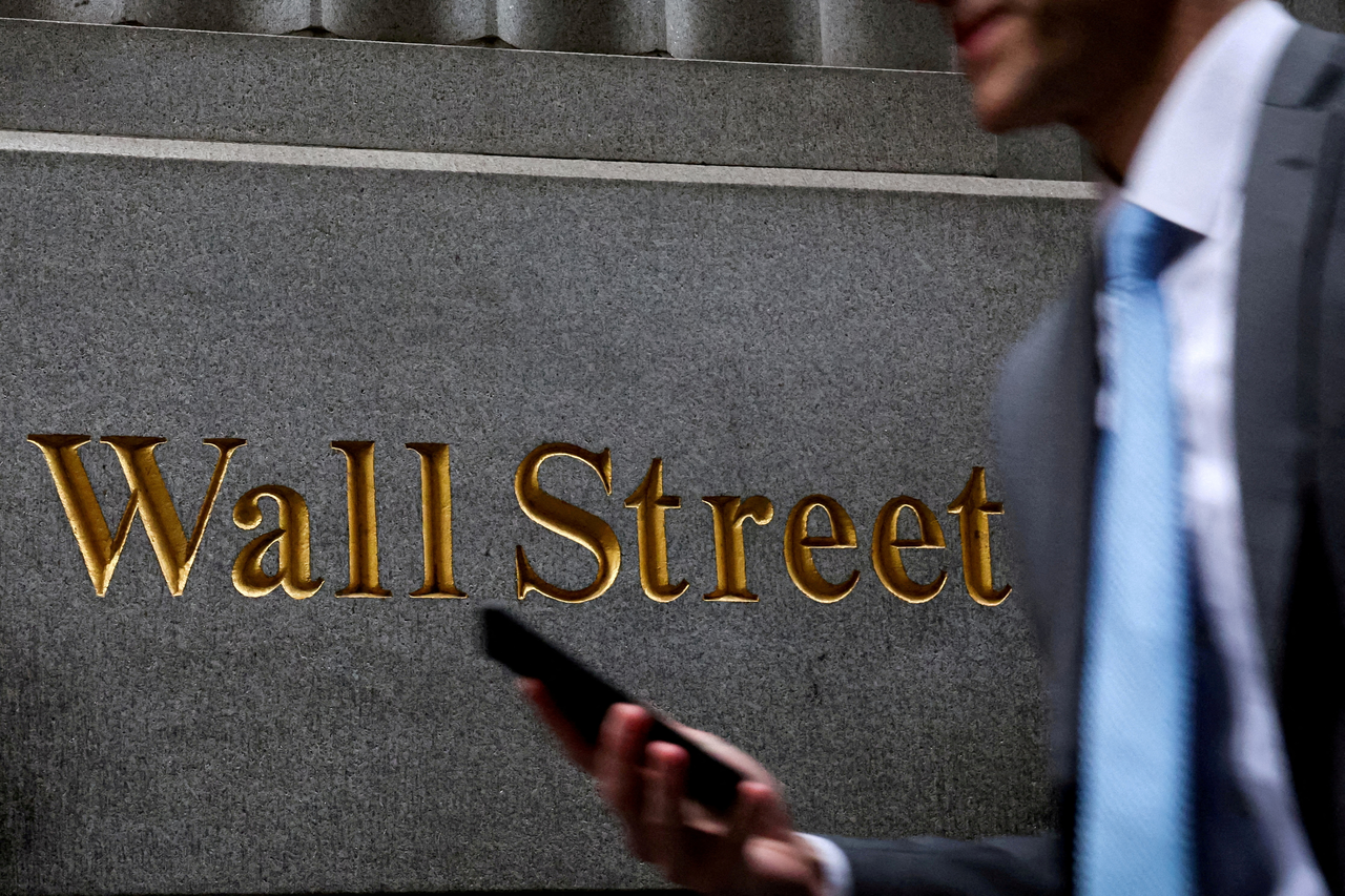 A man walks past the New York Stock Exchange on Wall Street in Manhattan, New York. (Reuters)