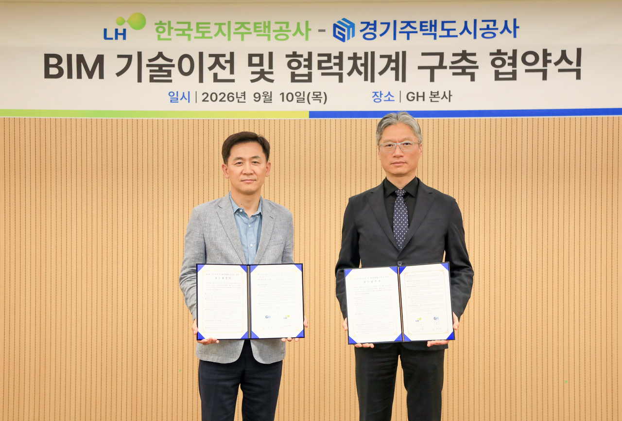 지난 10일 경기주택도시공사(GH) 본사에서 손준화(오른쪽) LH 스마트단지기술처장과 김재근 GH 건설기술처장이 BIM 기술이전 업무협약식 후 기념촬영을 하고 있다. [LH 제공]