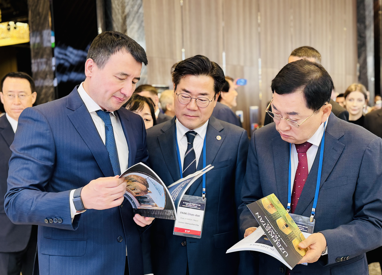 Uzbek Deputy Prime Minister Jamshid Khodjayev (left), Governors Association of the Republic of Korea President Park Chan-dae (center) and Gyeongju Mayor Joo Nak-yeong look through promotional materials and exchange information on the sidelines of an exhibition held during the first Uzbekistan-Korea Interregional Cooperation Forum at JW Marriott Dongdaemun Square Seoul on Friday. The exhibition highlighted key industries, including critical minerals, industrial supplies, textiles, food products and cultural heritage, showcasing opportunities for regional investment and cooperation between Uzbekistan and South Korea. (Sanjay Kumar/The Korea Herald)