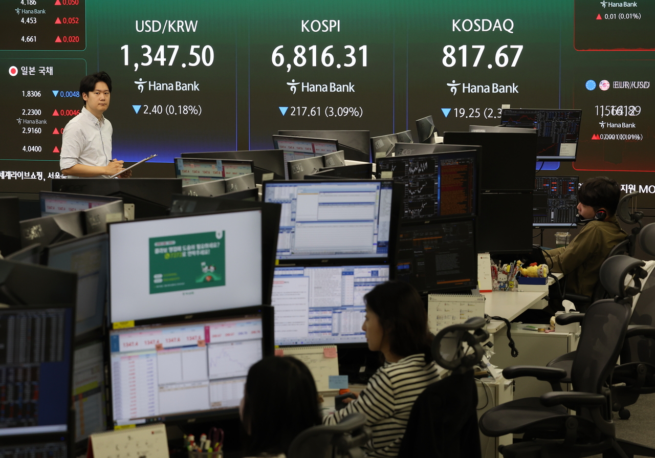 Employees work at the dealing room of Hana Bank's headquarters in Jung-gu, Seoul, on Friday. (Yonhap)