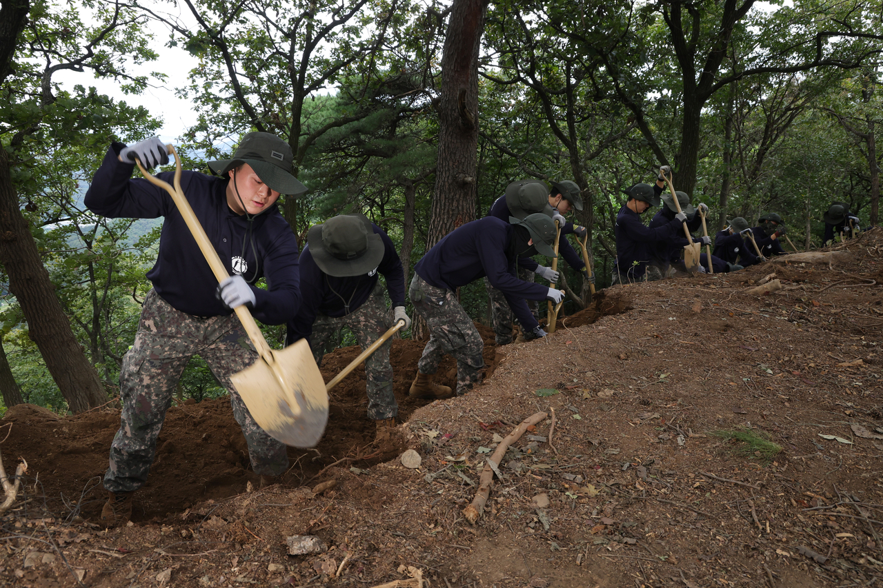 Soldiers shovel earth to search for war remains during an excavation in Paju, Gyeonggi Province, on Thursday. (Yonhap)