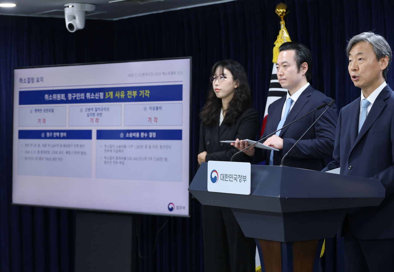 Kang Jun-ha (right), director general of the International Legal Affairs Bureau at the  Ministry of Justice, briefs reporters on South Korea's victory in an investor-state dispute brought by a Chinese investor in Seoul on Sunday. (Yonhap)