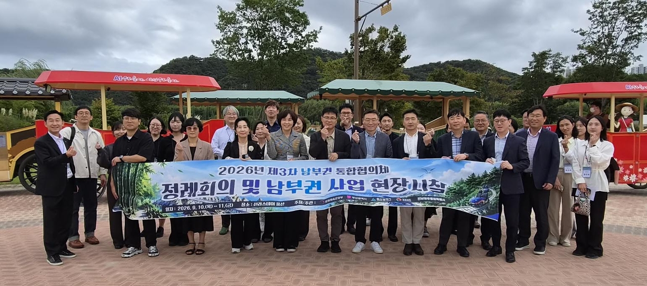 2026년 제3차 남부권 광역관광 통합협의체 정례회의 참가자들이 10일 울산시가 세계적인 정원도시 조성을 위해 친환경 이동수단인 전기동력 ‘울산 마차’가 운행 중인 태화강국가정원에서 울산 마차를 체험한 뒤 기념촬영을 하고 있다. [울산시 제공]