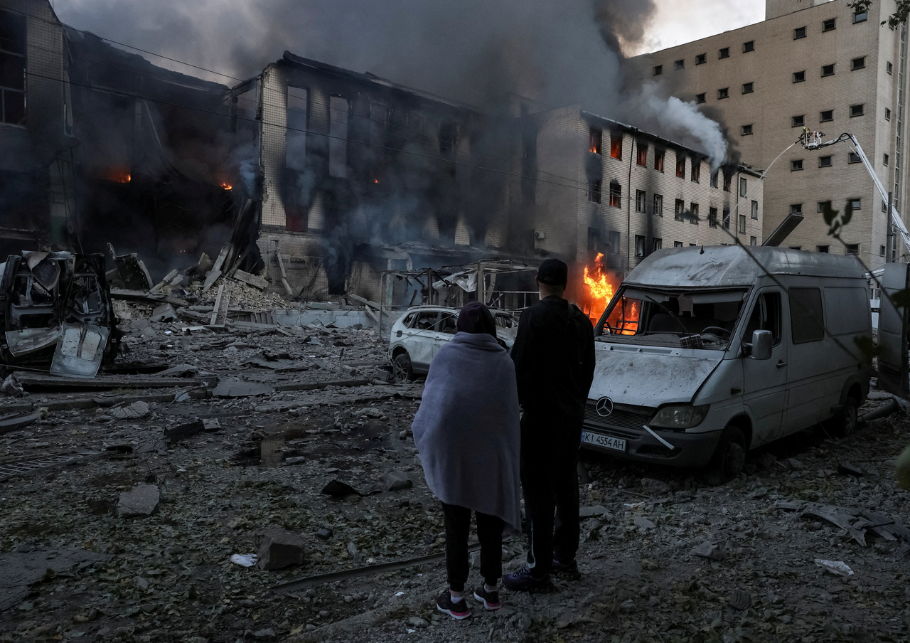 Residents stand at a site of a Russian missile attack in Kyiv, Ukraine, Tuesday. (Reuters-Yonhap)