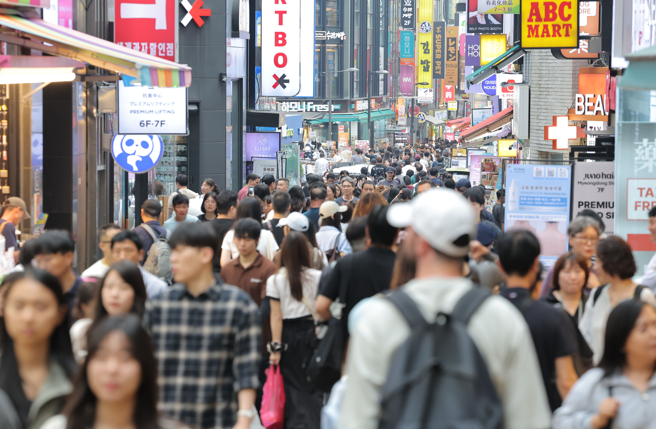 Tourists and passerbys fill the streets of Myeong-dong in central Seoul on Sunday. (Yonhap)